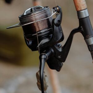 Detailed view of a fishing reel attached to a rod, perfect for angling enthusiasts.